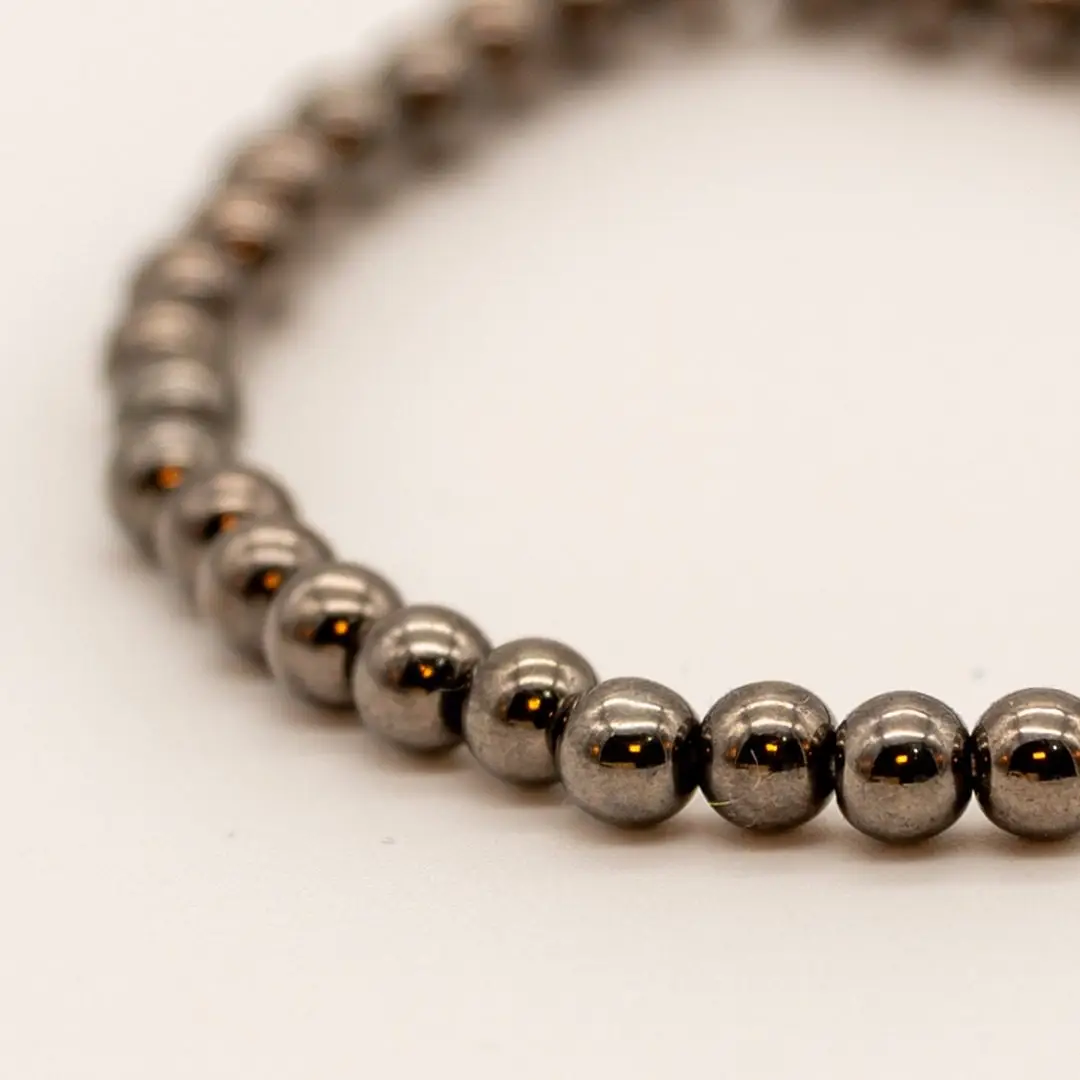 Pormenor da Pulseira Aço Fumado — Contas pequenas metálicas cinza-escuro (tipo hematite/aço), fio elástico